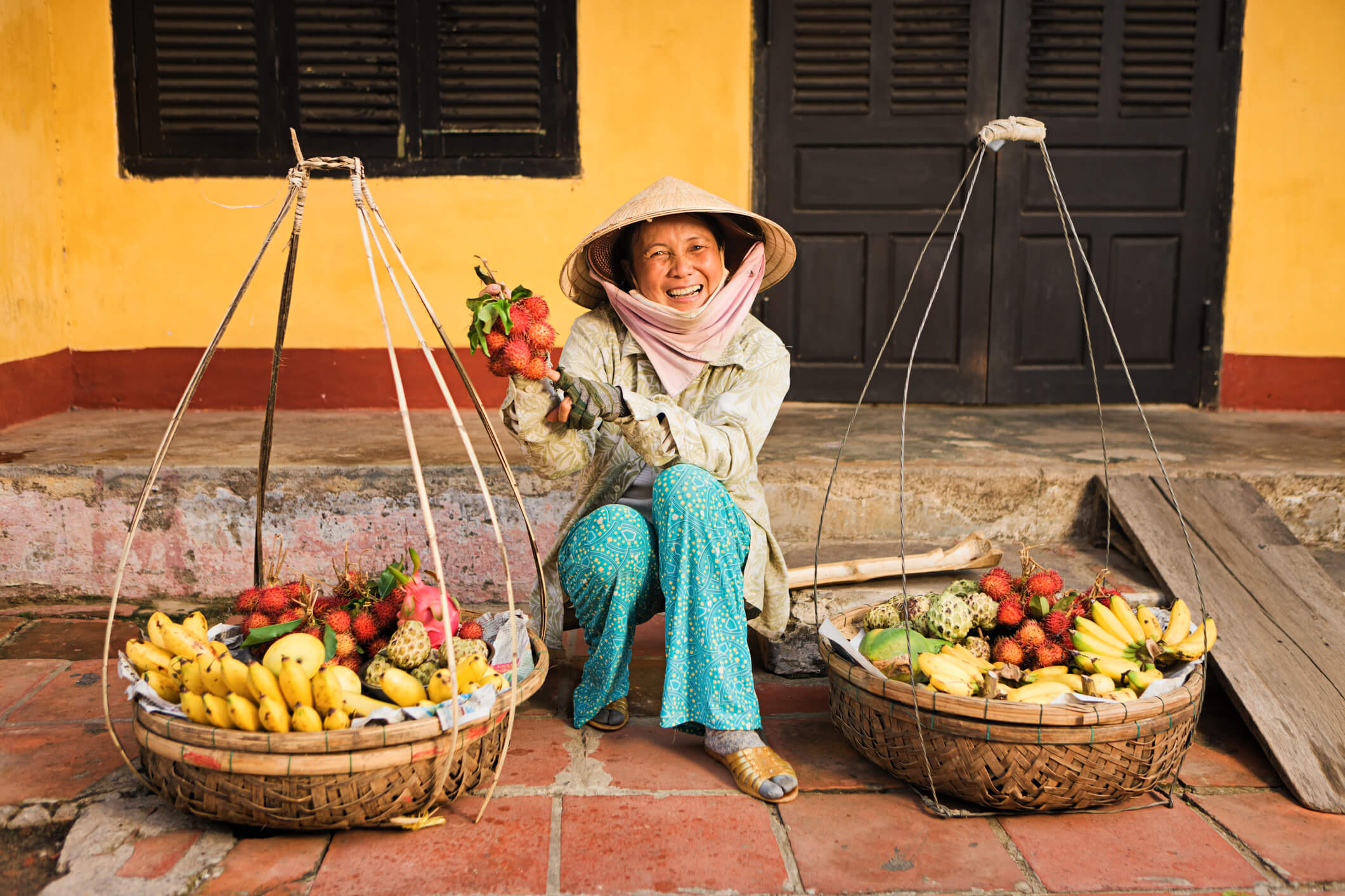 Local street vendor with fruit baskets - authentic scene featured on Da Nang Food Tours