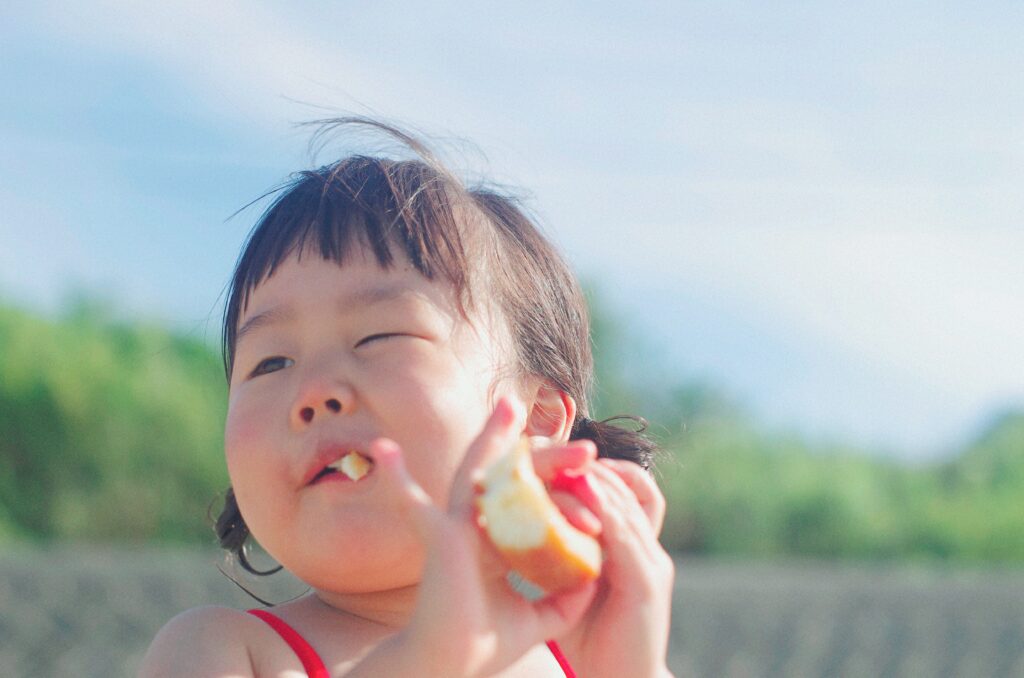 Young child enjoying a snack on a family food tour in Da Nang